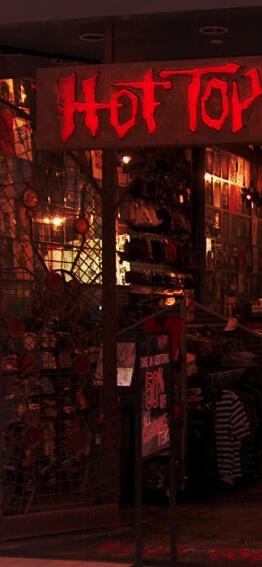 Photography of the outside of a Hot Topic. There is a warm tint to it.